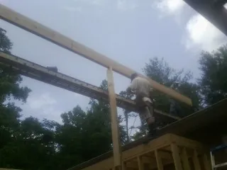 Carpenter setting a ridge beam over a new addition frame — Ice Dam Removal by Roofing Brothers in Danube