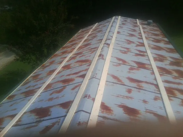 Rusted metal roof panels with new wood purlins before replacement — Storm Damage Roof Repair in Danube by Roofing Brothers