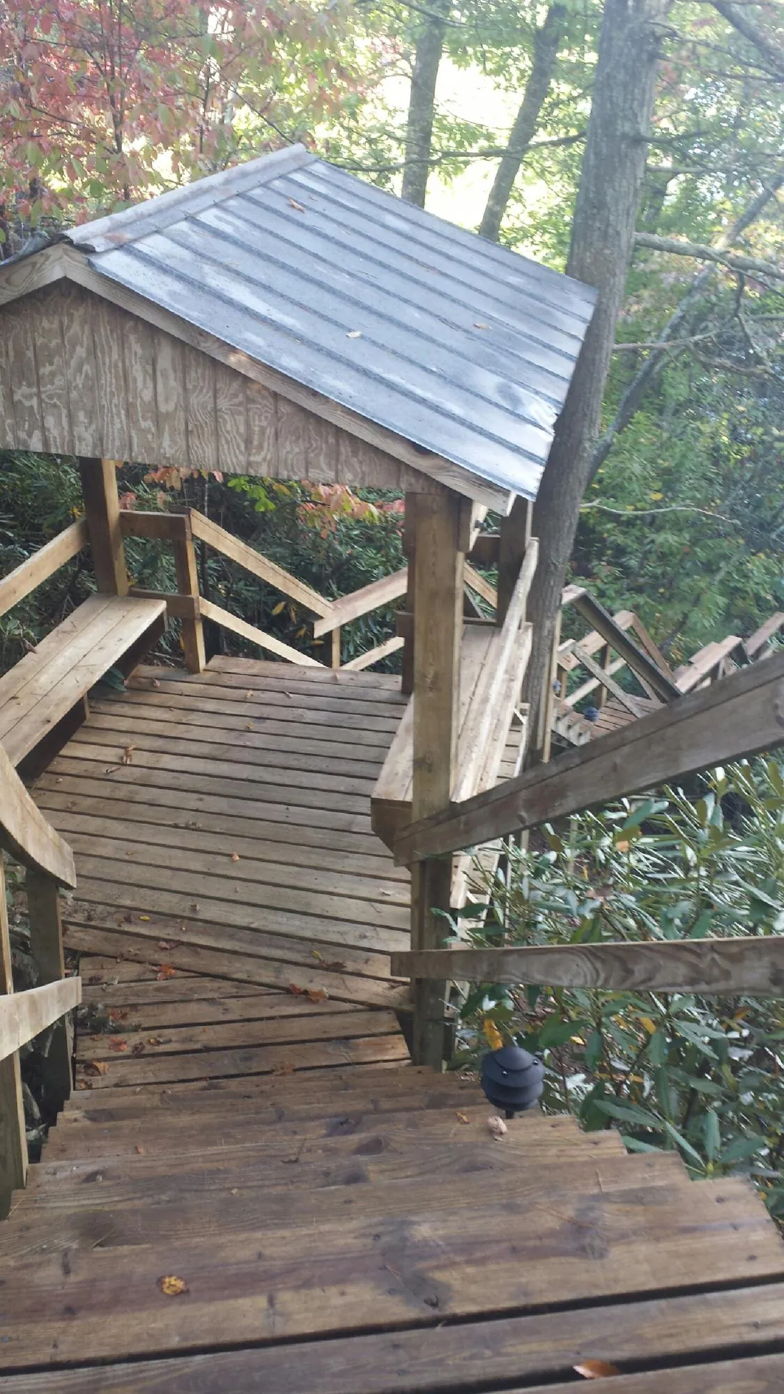 Metal roofed shelter over wooden steps on a wooded walkway — Skylight Repair & Installation work by our crew in Danube