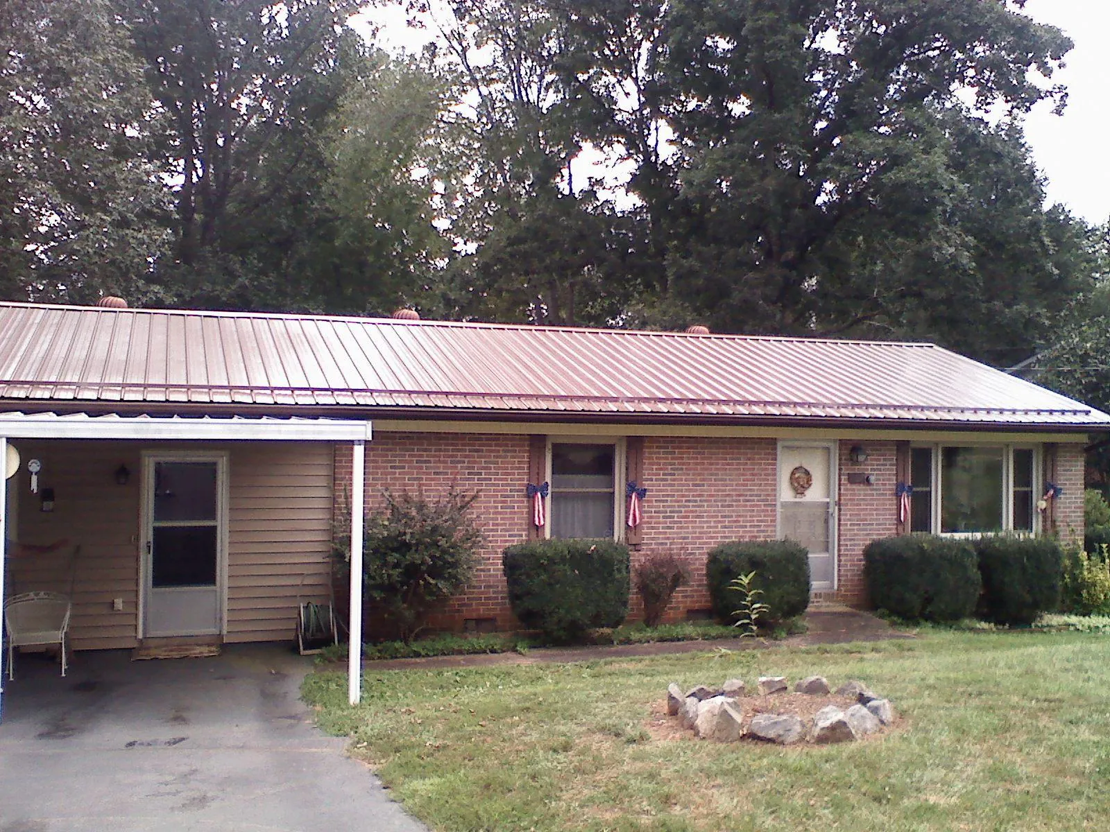 Bronze metal roof and carport on a brick ranch home — Roof Repair work by our crew in Danube